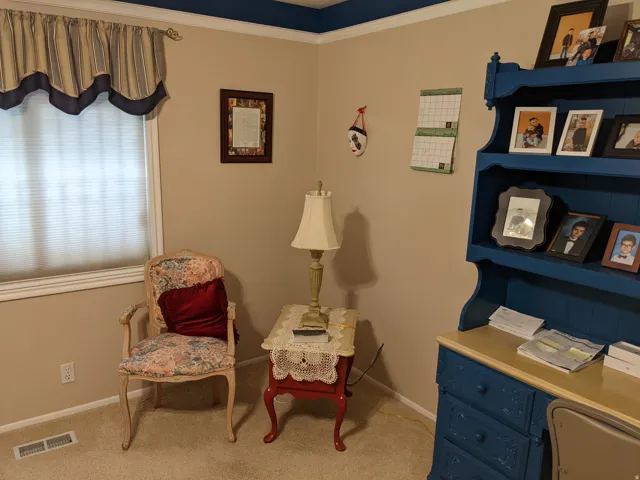 Sitting room featuring light colored carpet and ornamental molding