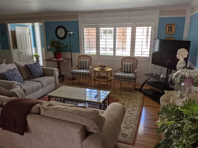Living area with wood finished floors and crown molding