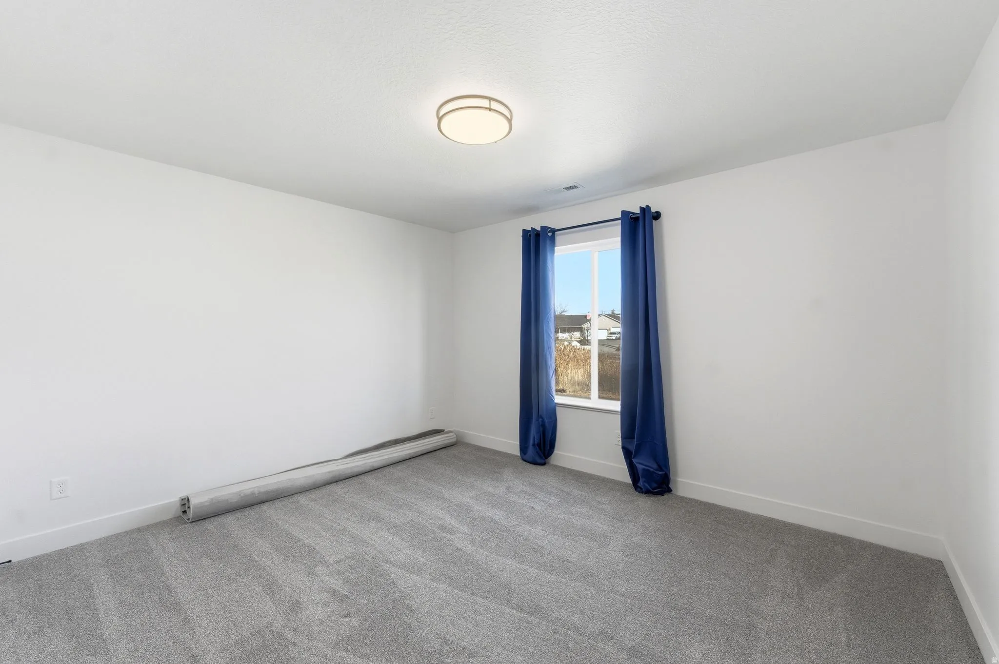 Empty room with light carpet and baseboards