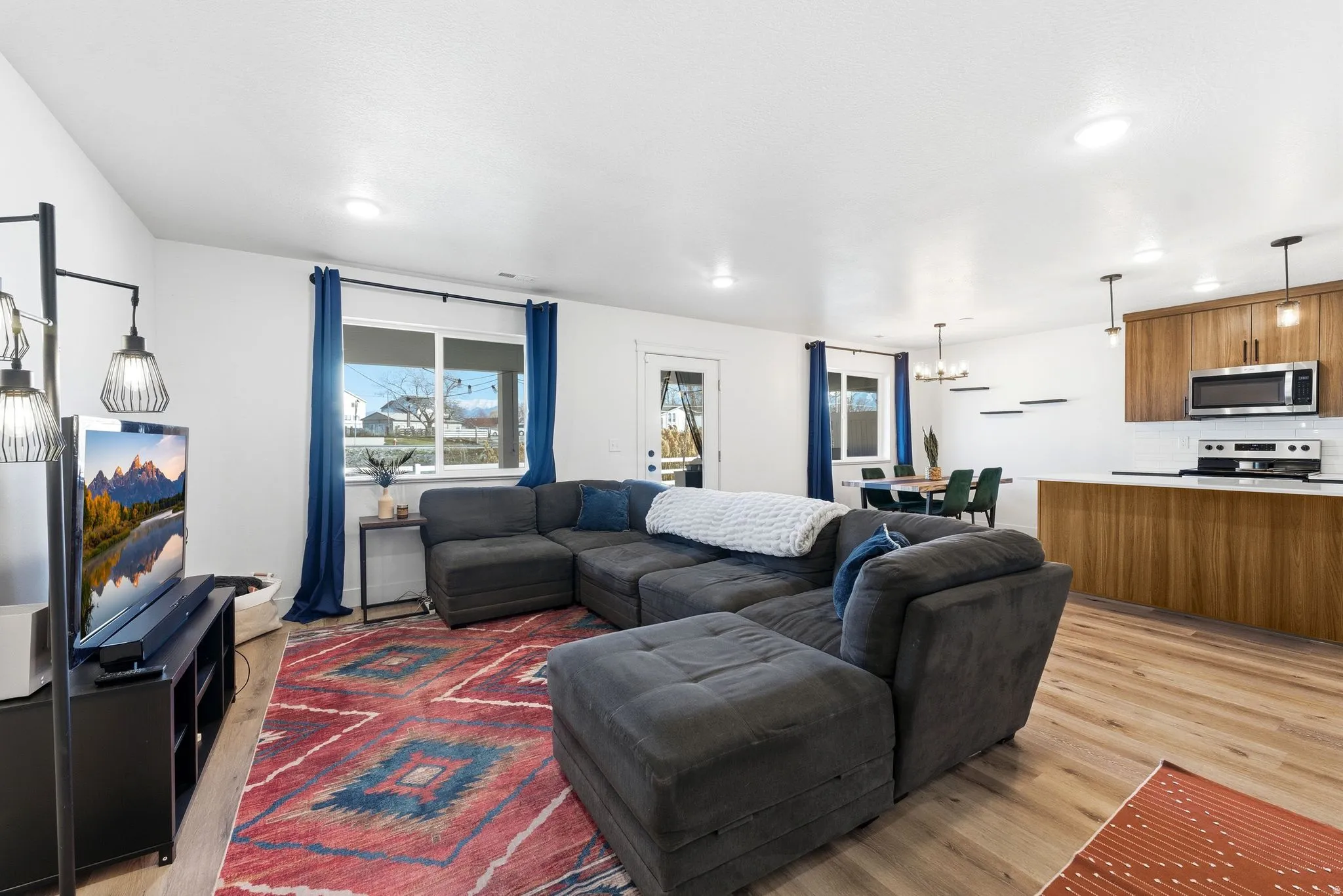 Living area featuring light wood-type flooring and suspended lighting