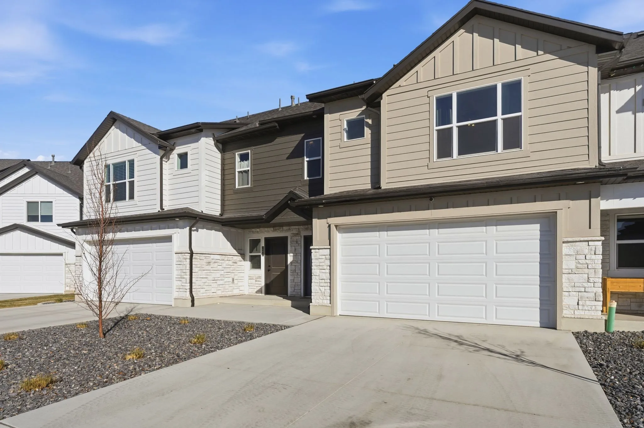 Craftsman house with stone siding, board and batten siding, and a garage