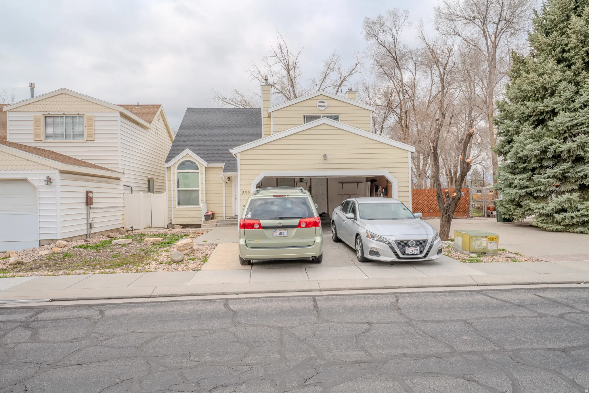 View of front of house featuring driveway, a chimney, and an attached garage