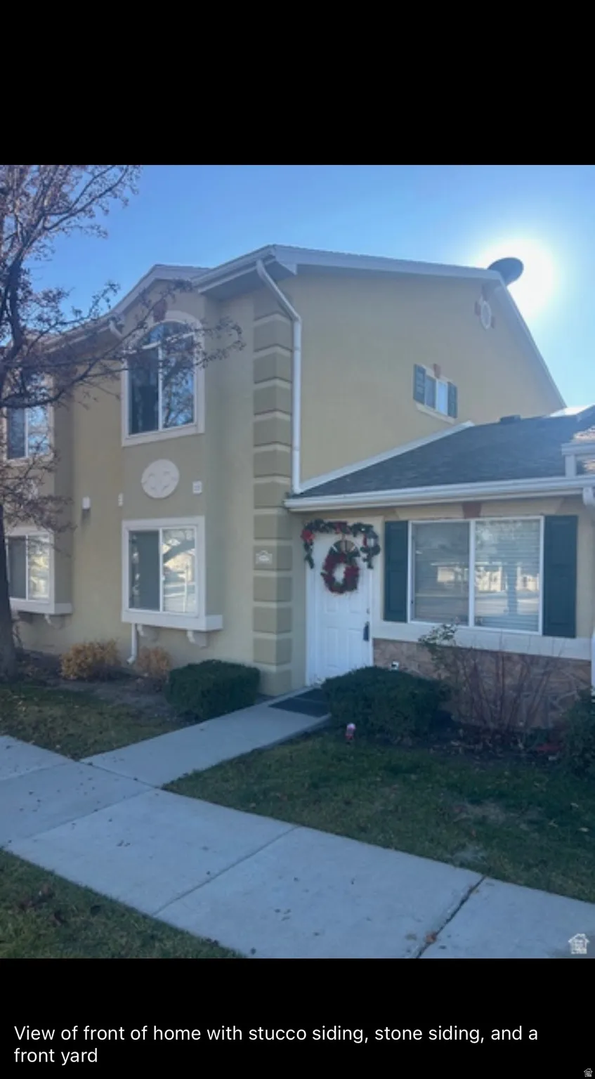 View of front of property featuring stucco siding and a front yard