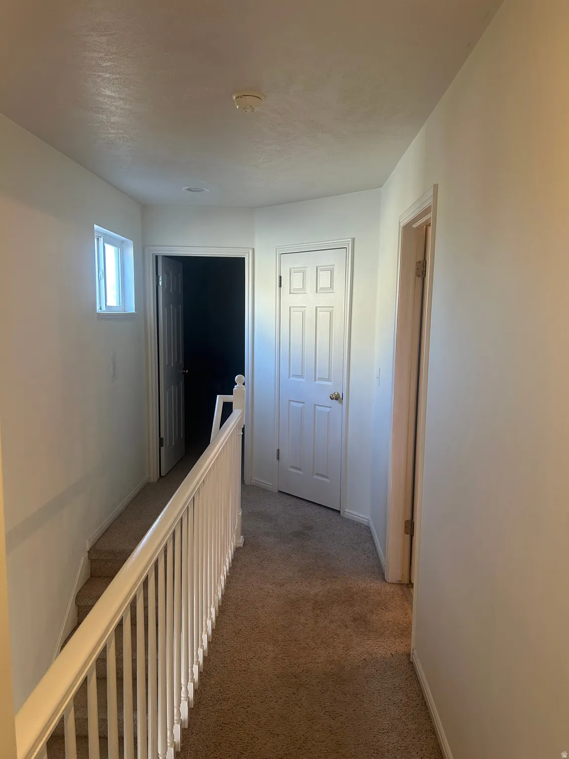 Hallway featuring carpet and an upstairs landing