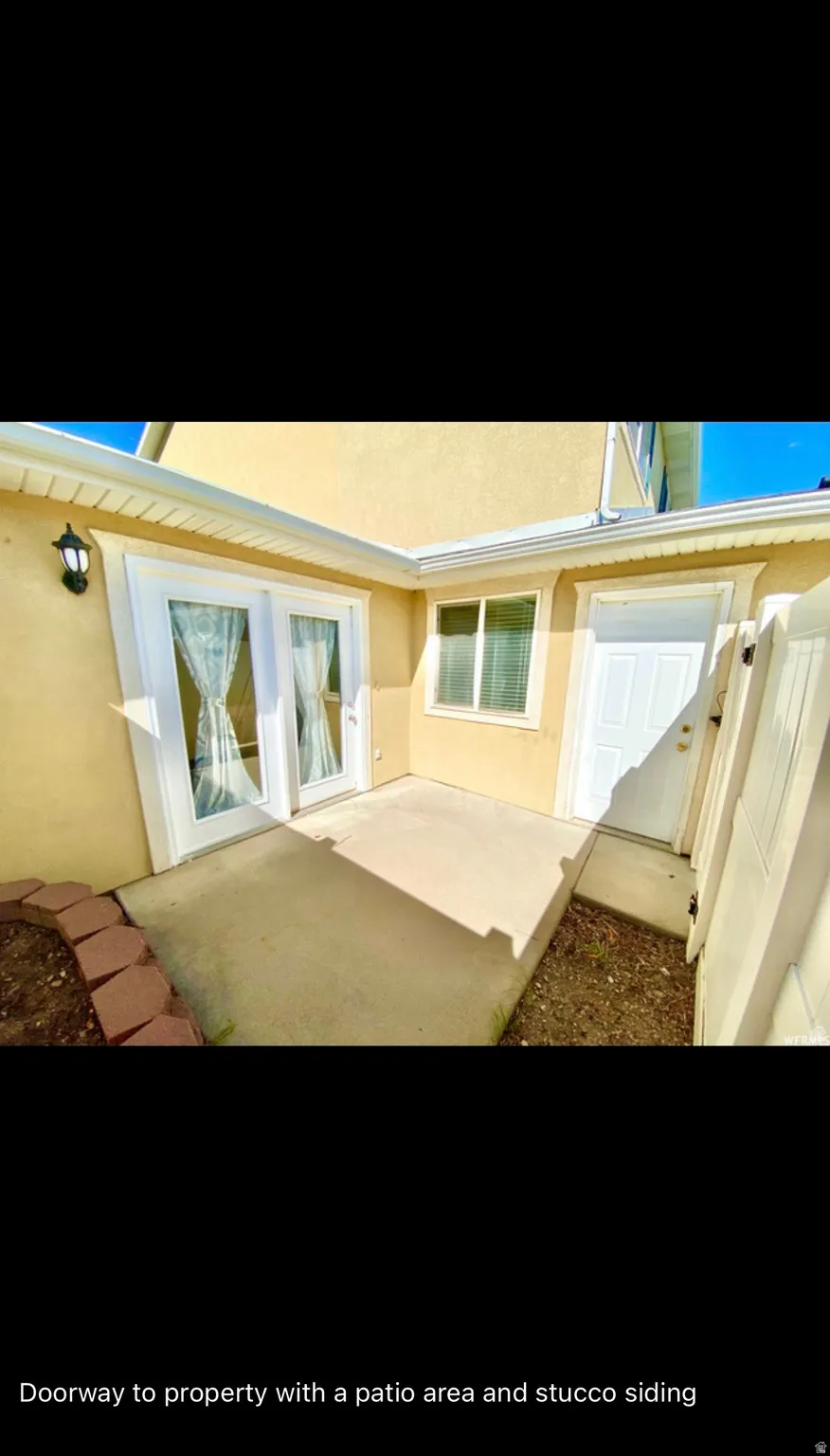 Entrance to property featuring a patio and stucco siding