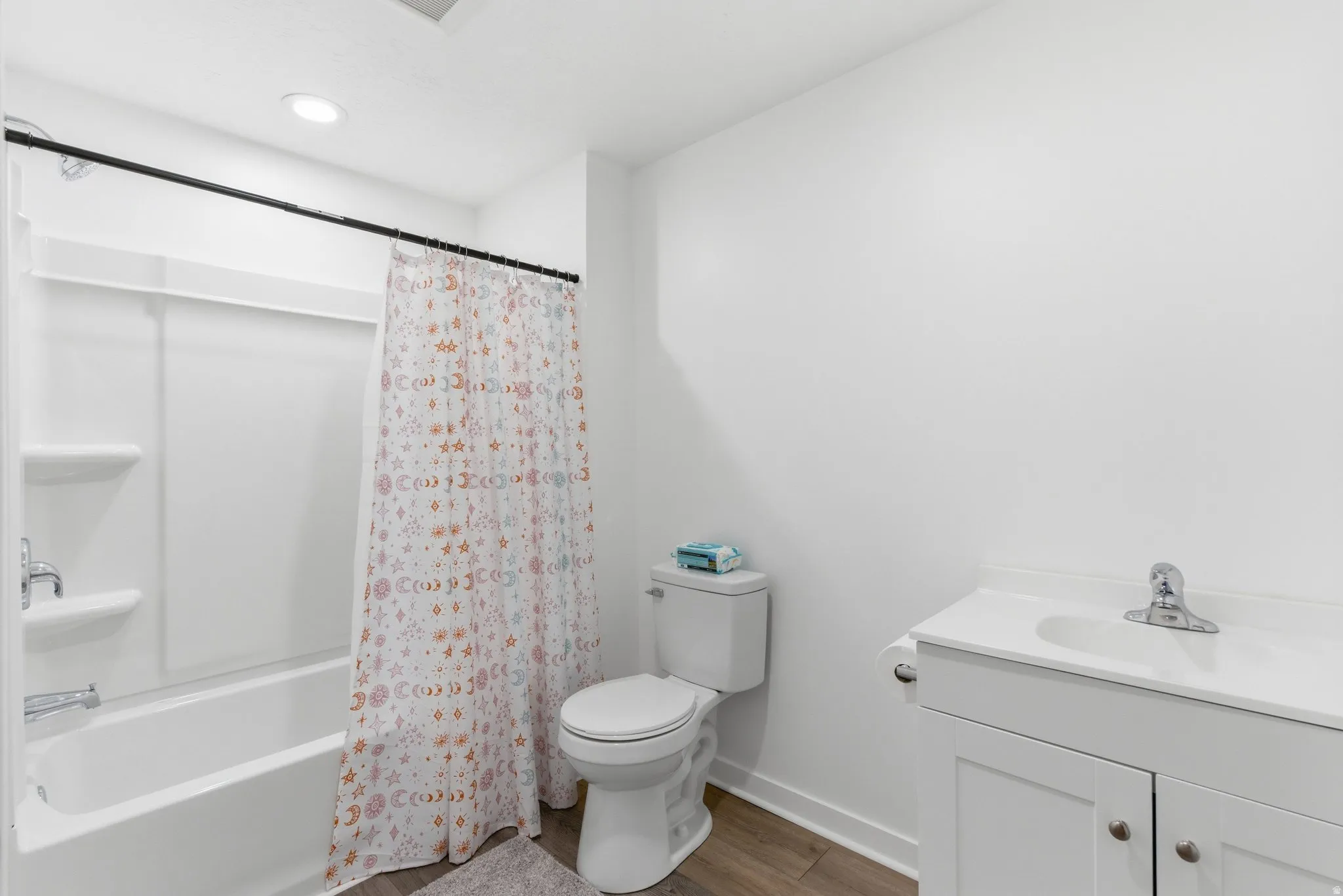 Full bath with vanity, shower / tub combo, and dark wood-type flooring