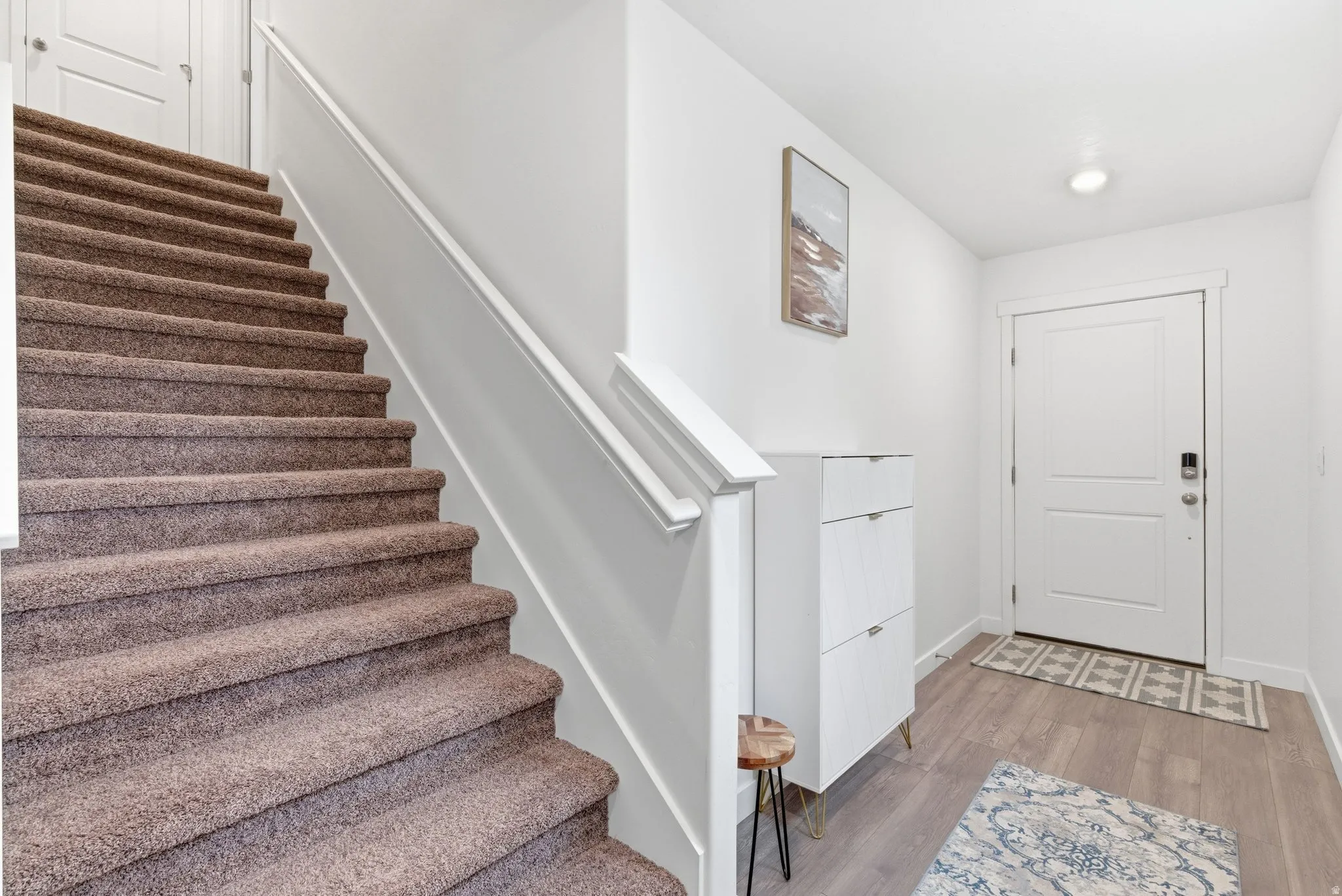 Foyer entrance with stairway and light wood-style flooring