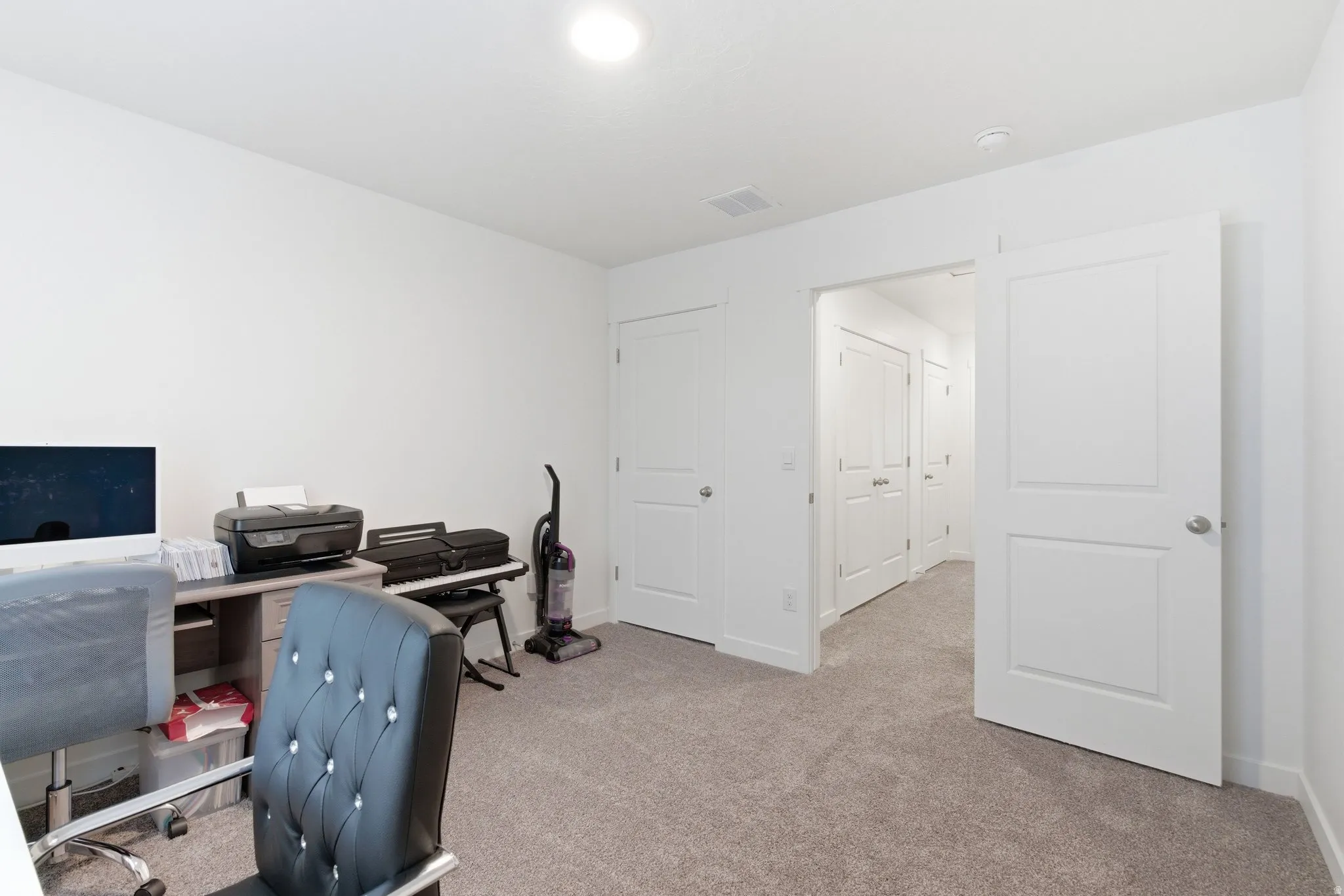 Home office with light carpet and baseboards