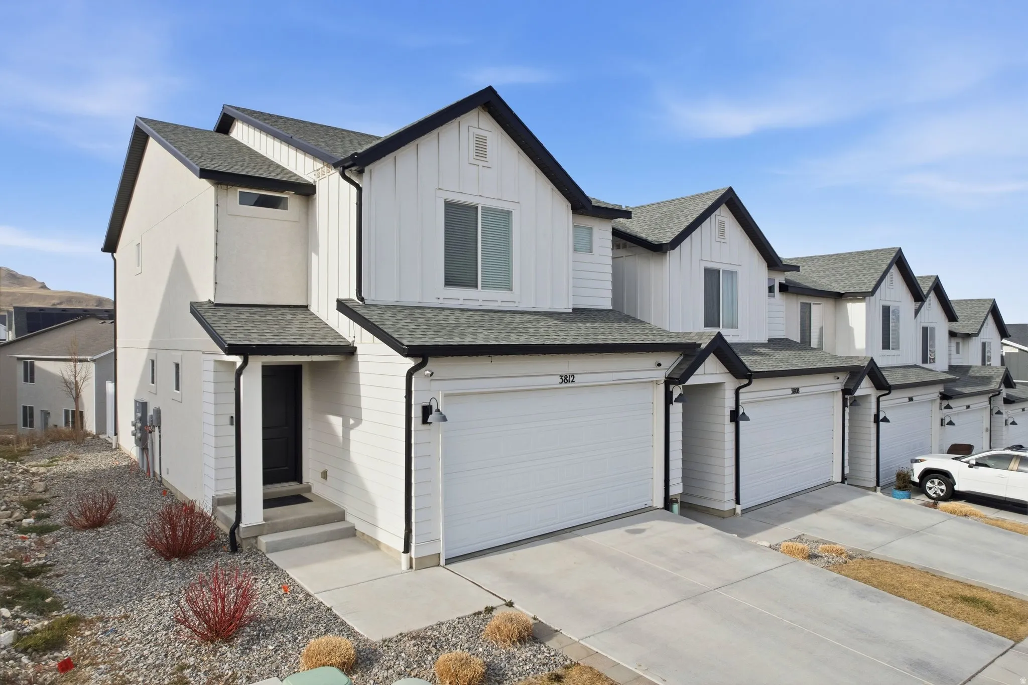 Modern inspired farmhouse with board and batten siding, a shingled roof, and a residential view