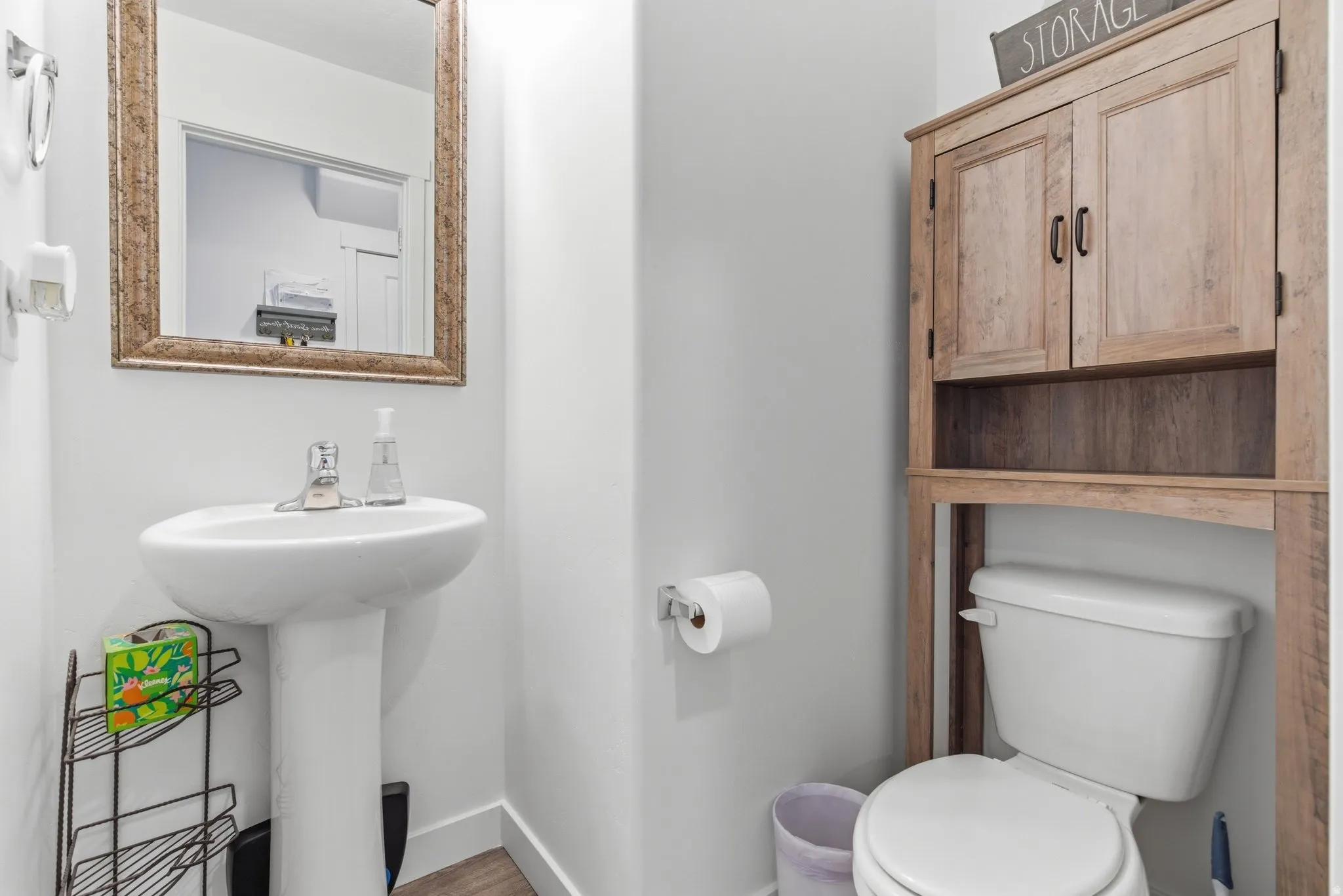 Half bathroom featuring toilet and light wood-style flooring