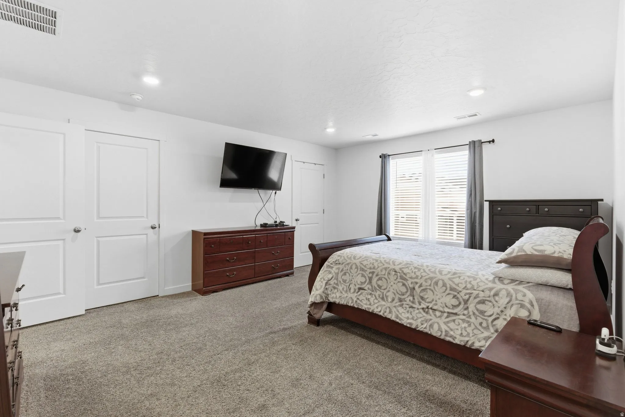 Bedroom with light carpet and recessed lighting