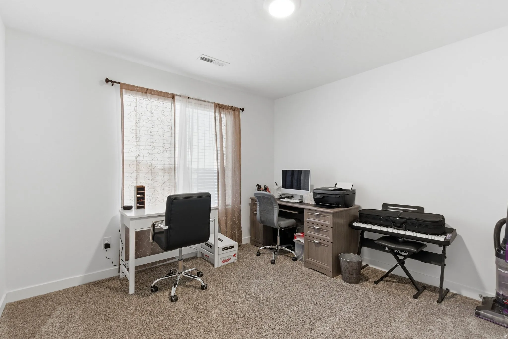 Office area with baseboards and light colored carpet