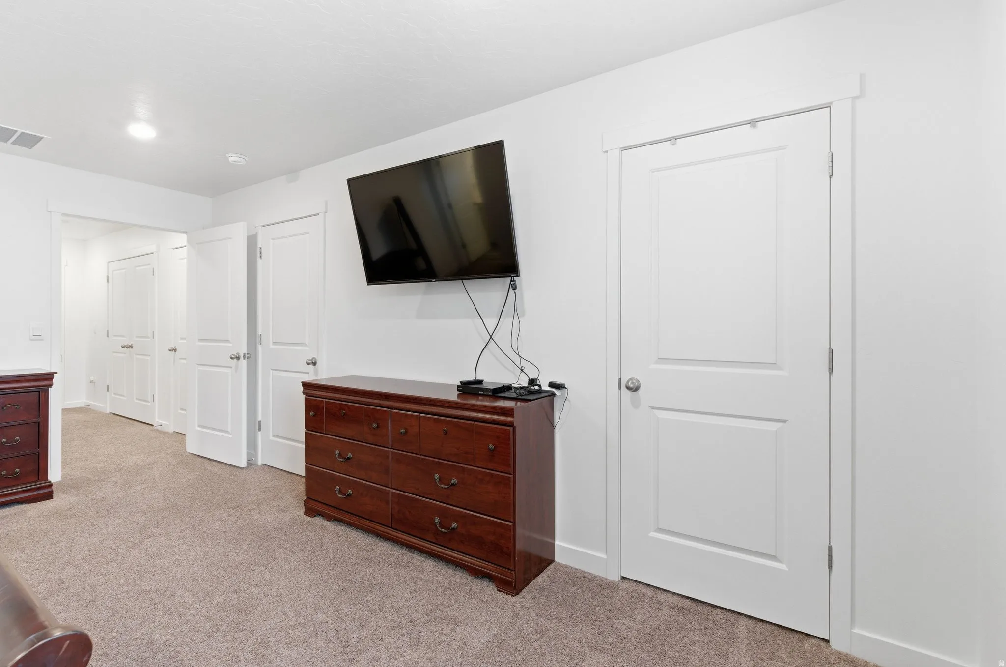 Bedroom with light colored carpet and baseboards