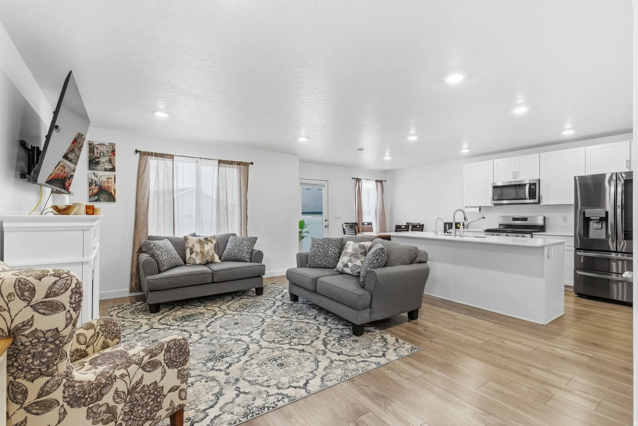 Living area with light wood-type flooring and recessed lighting