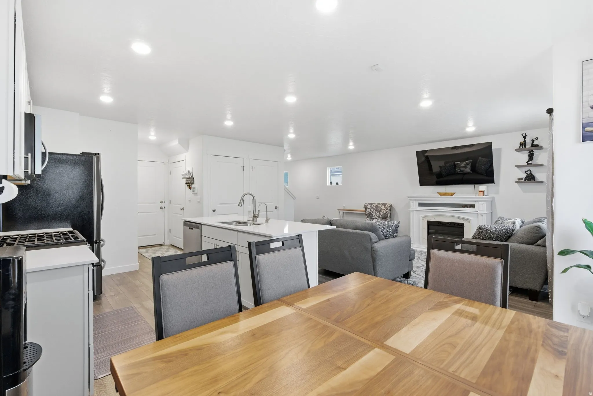 Dining area with a glass covered fireplace, light wood-style flooring, and recessed lighting
