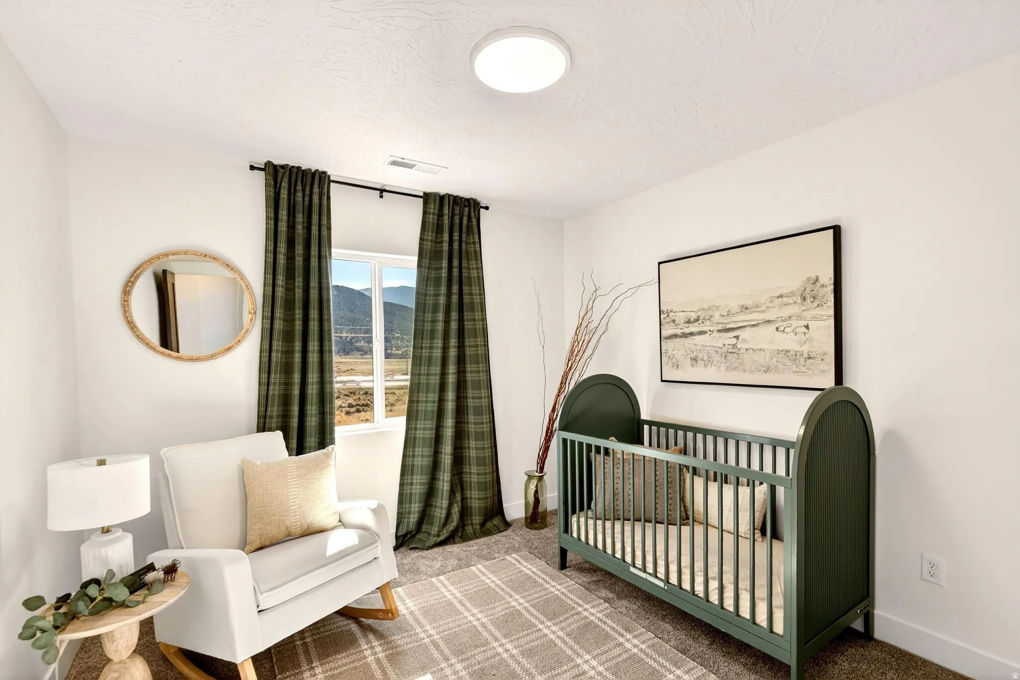 Carpeted bedroom featuring a nursery area and baseboards