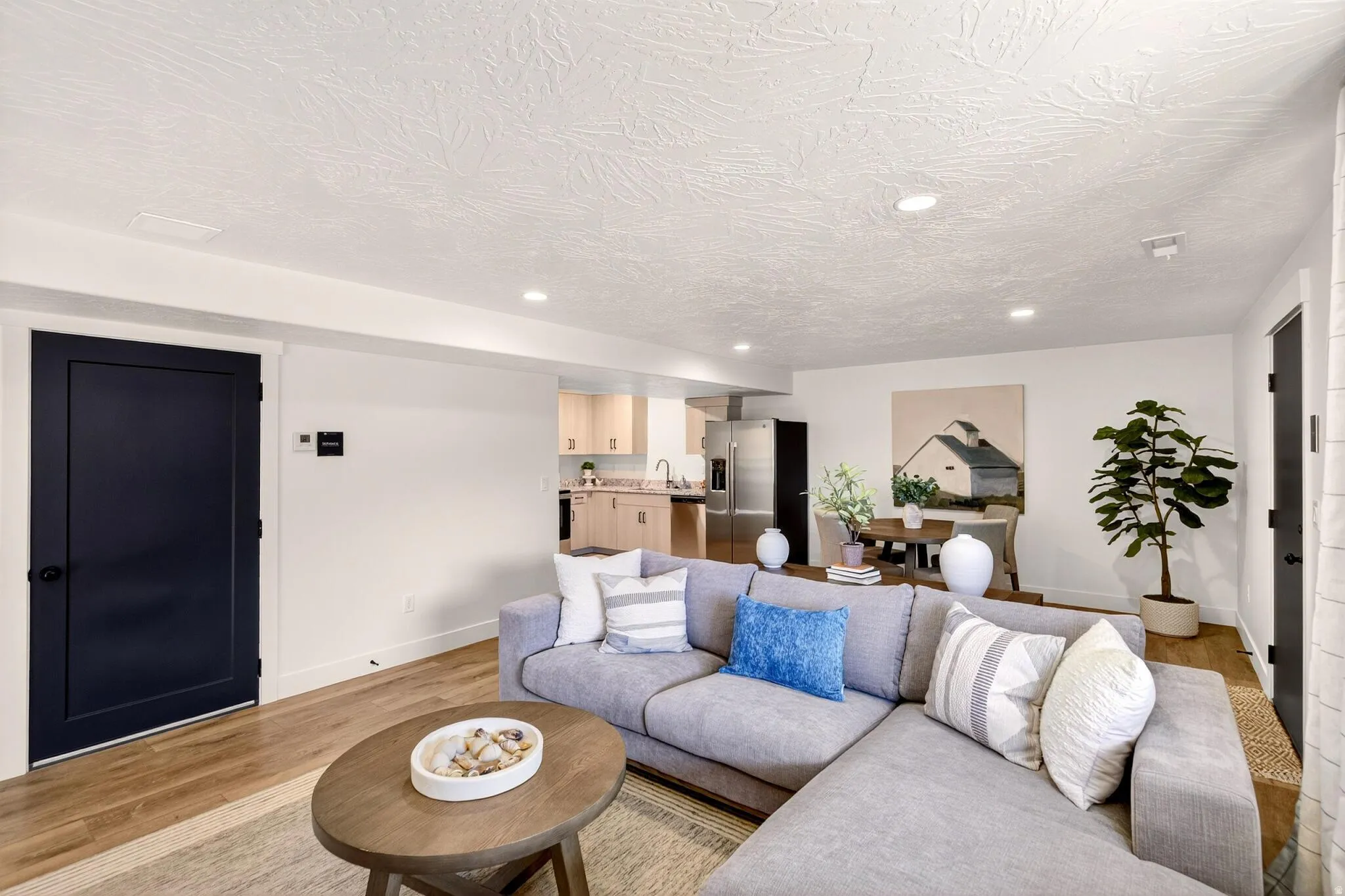 ADU Living room with light wood-type flooring, recessed lighting, and a textured ceiling.
