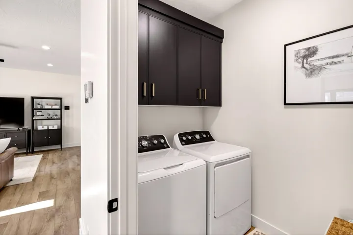 Laundry area with light wood finished floors, cabinet space, independent washer and dryer, and recessed lighting