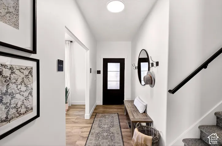 Entryway featuring stairway and light wood-style floors