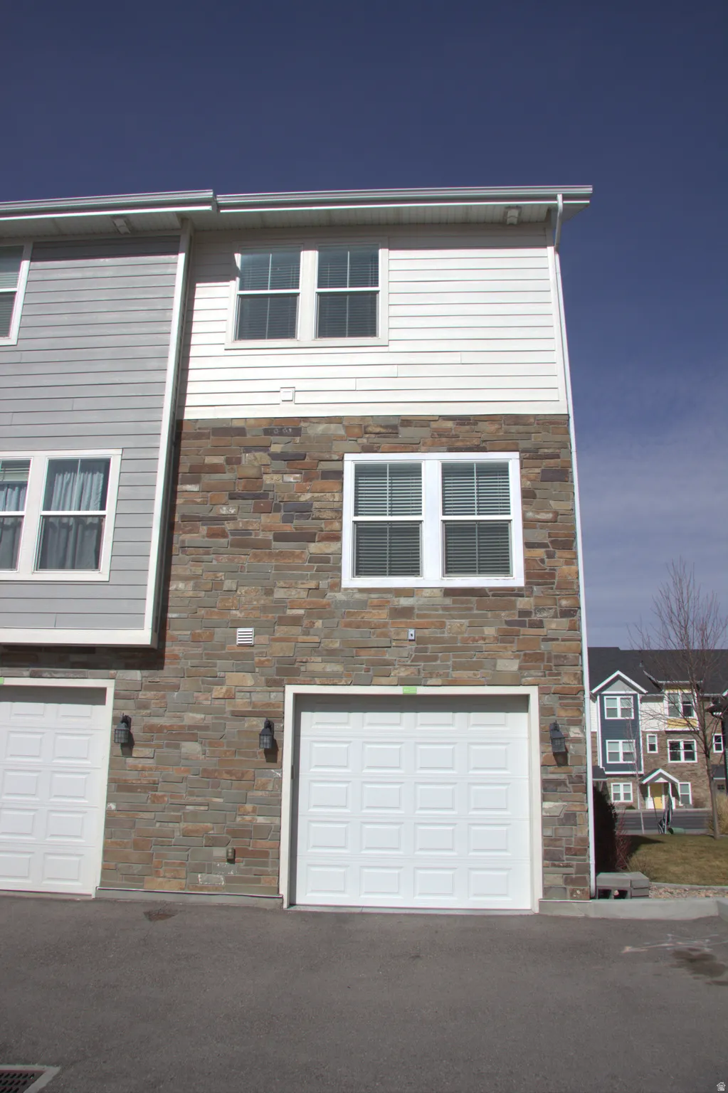 View of front facade with stone siding and an attached garage