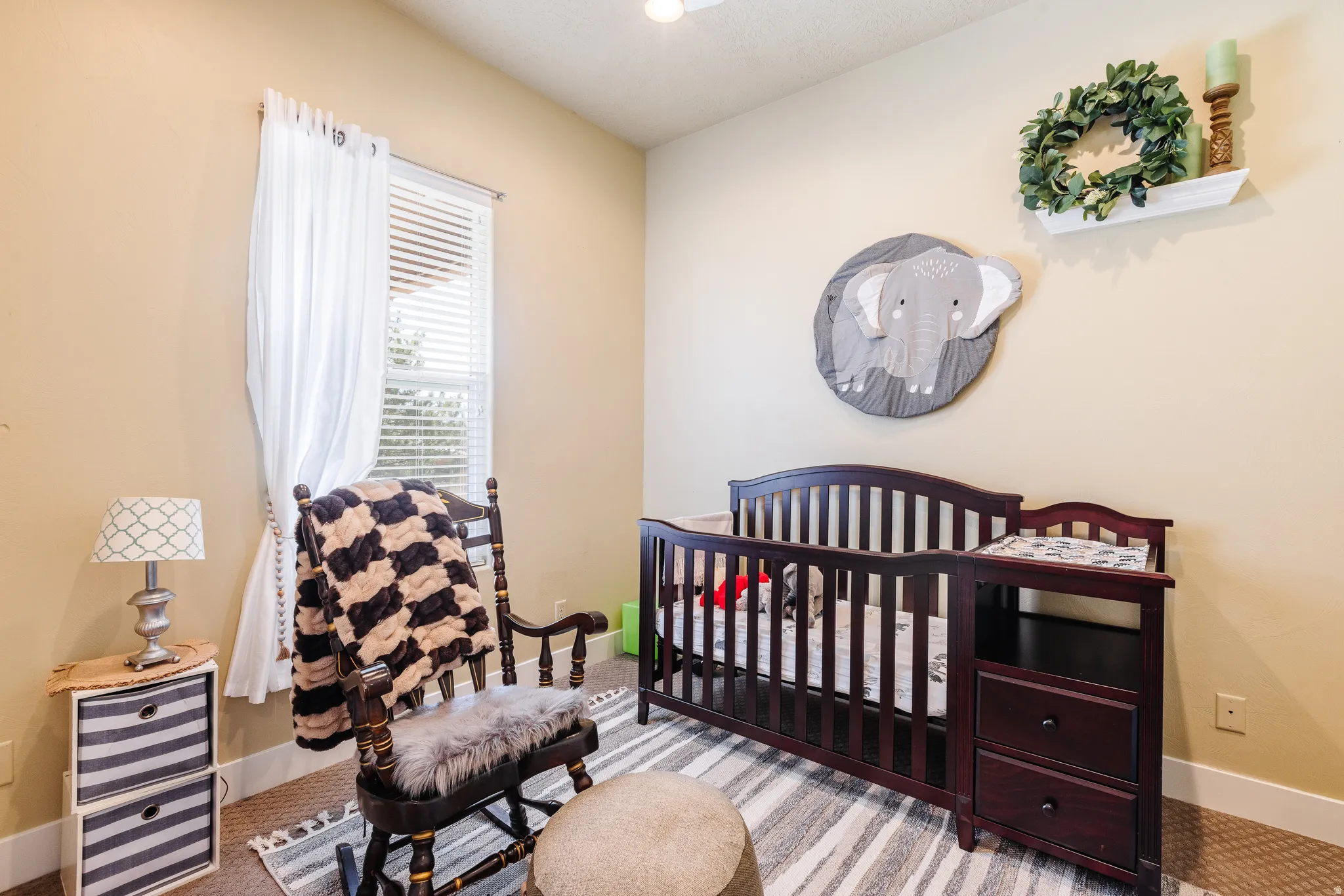 Bedroom with a crib, wine cooler, and carpet