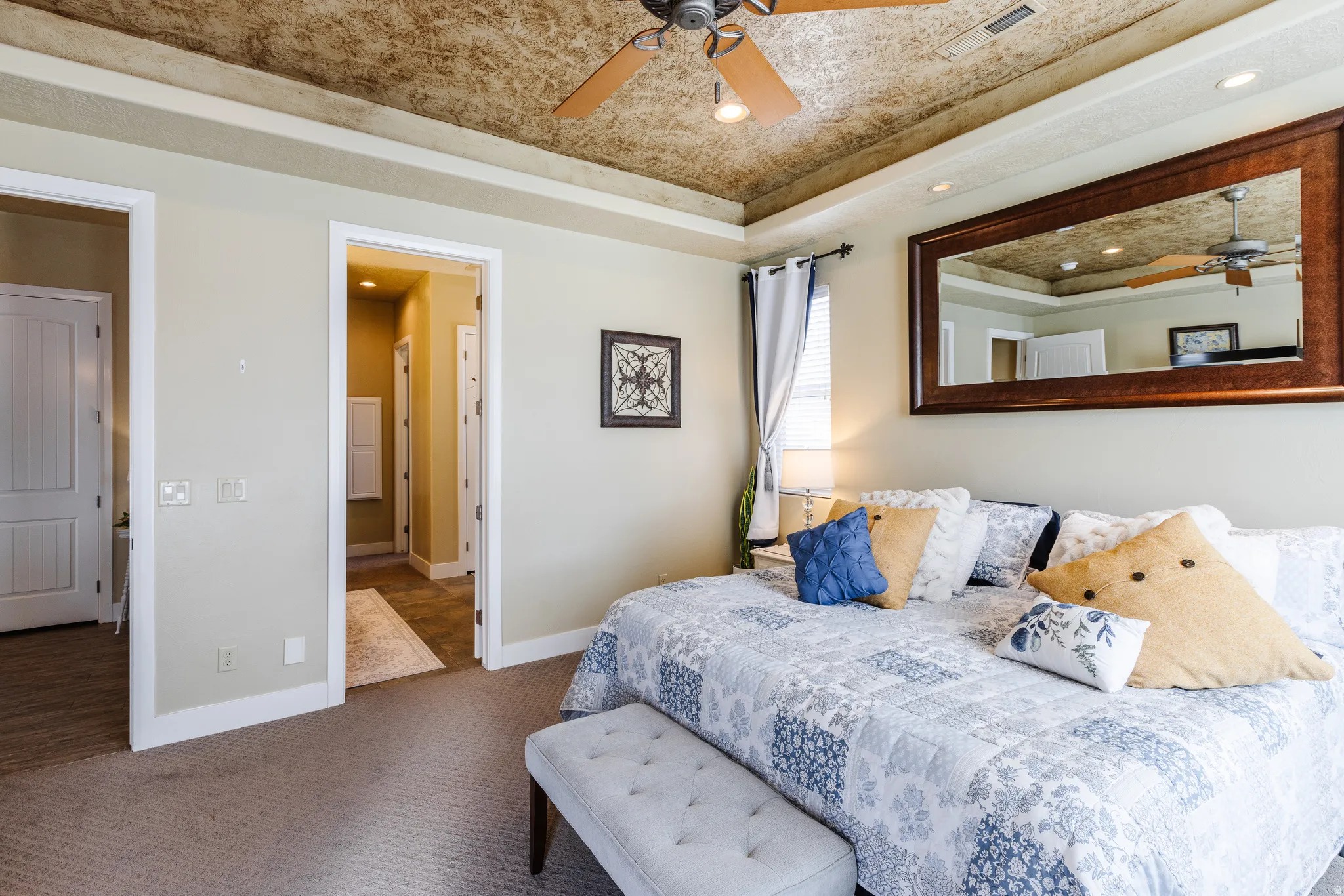 Carpeted bedroom with recessed lighting, a raised ceiling, and a ceiling fan
