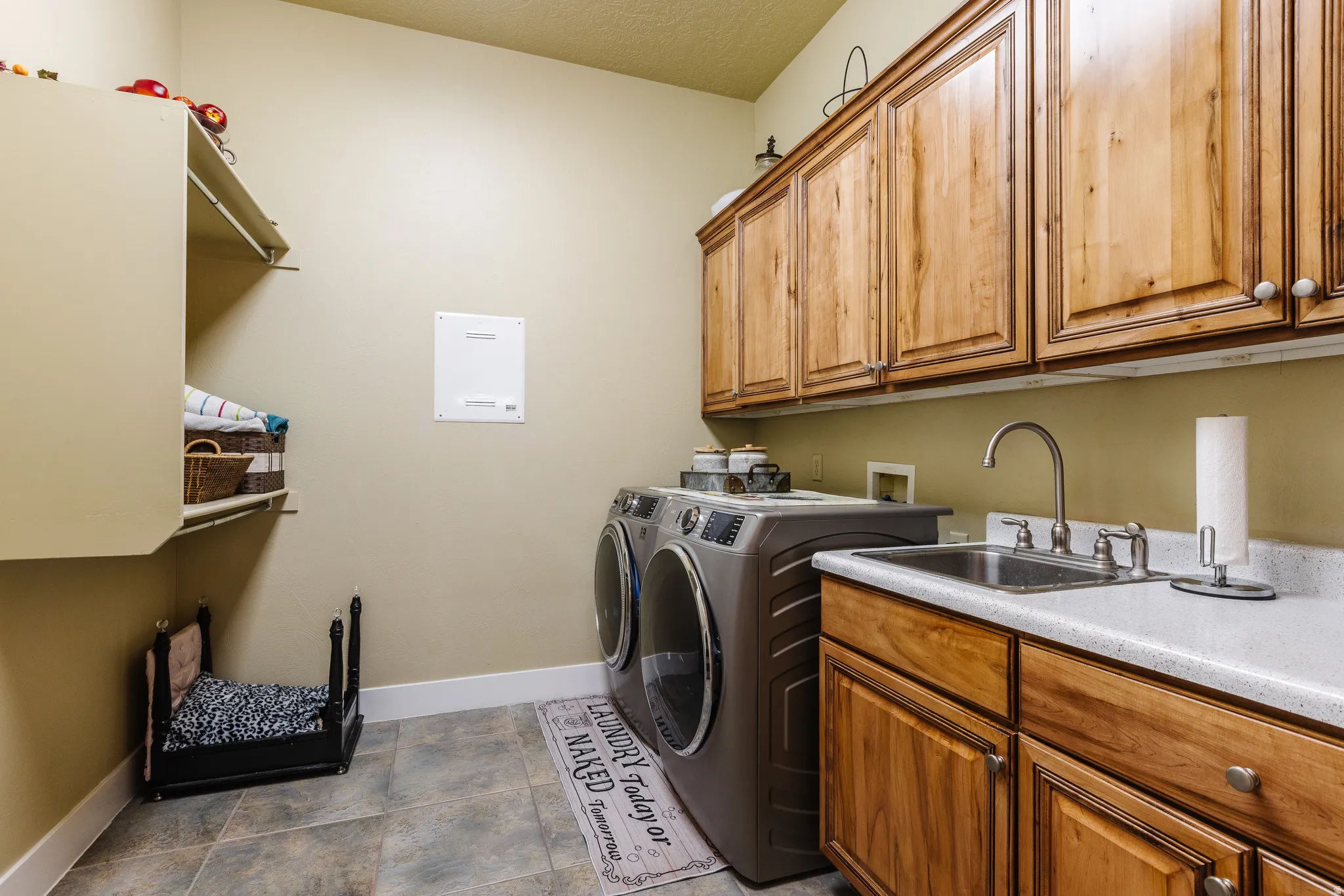 Laundry room with cabinet space, washer and clothes dryer, and a textured ceiling