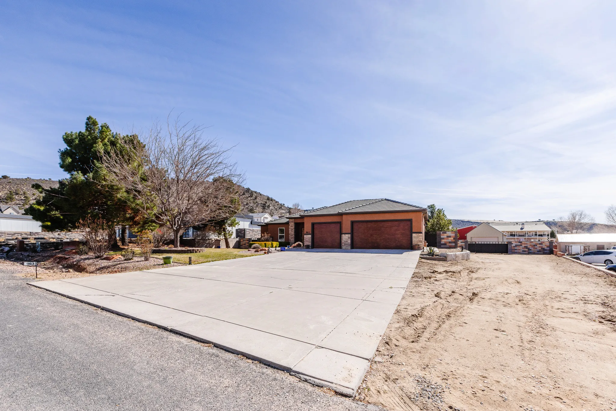 View of front of home featuring concrete driveway, stone siding, and an attached garage