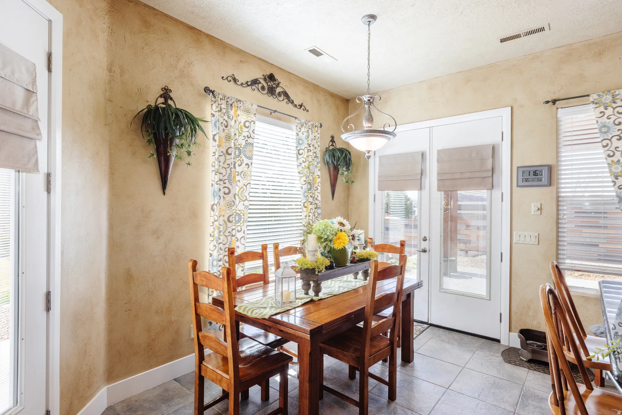 Dining space featuring a textured wall, light tile patterned floors, and a textured ceiling