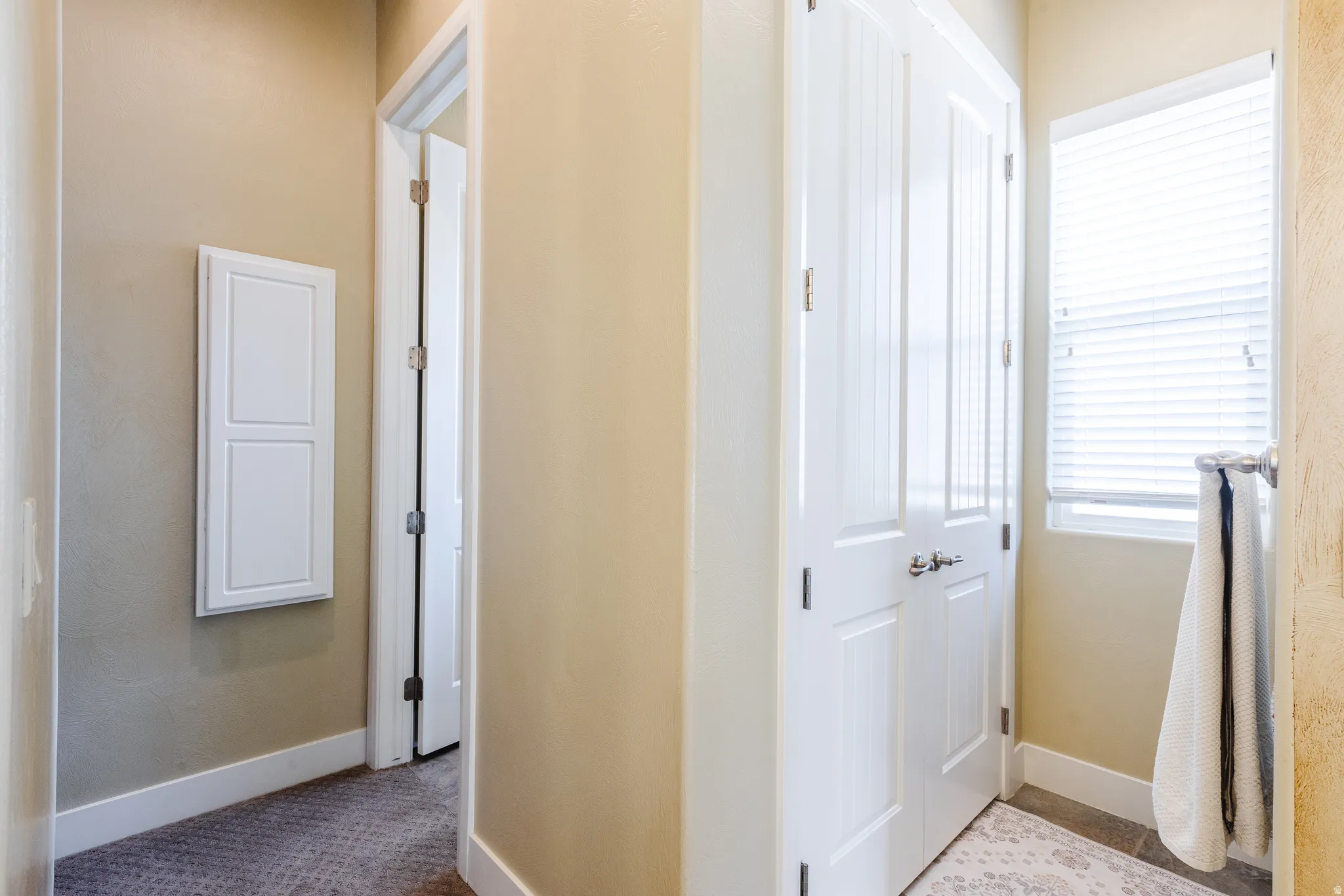 Hall featuring baseboards and light colored carpet