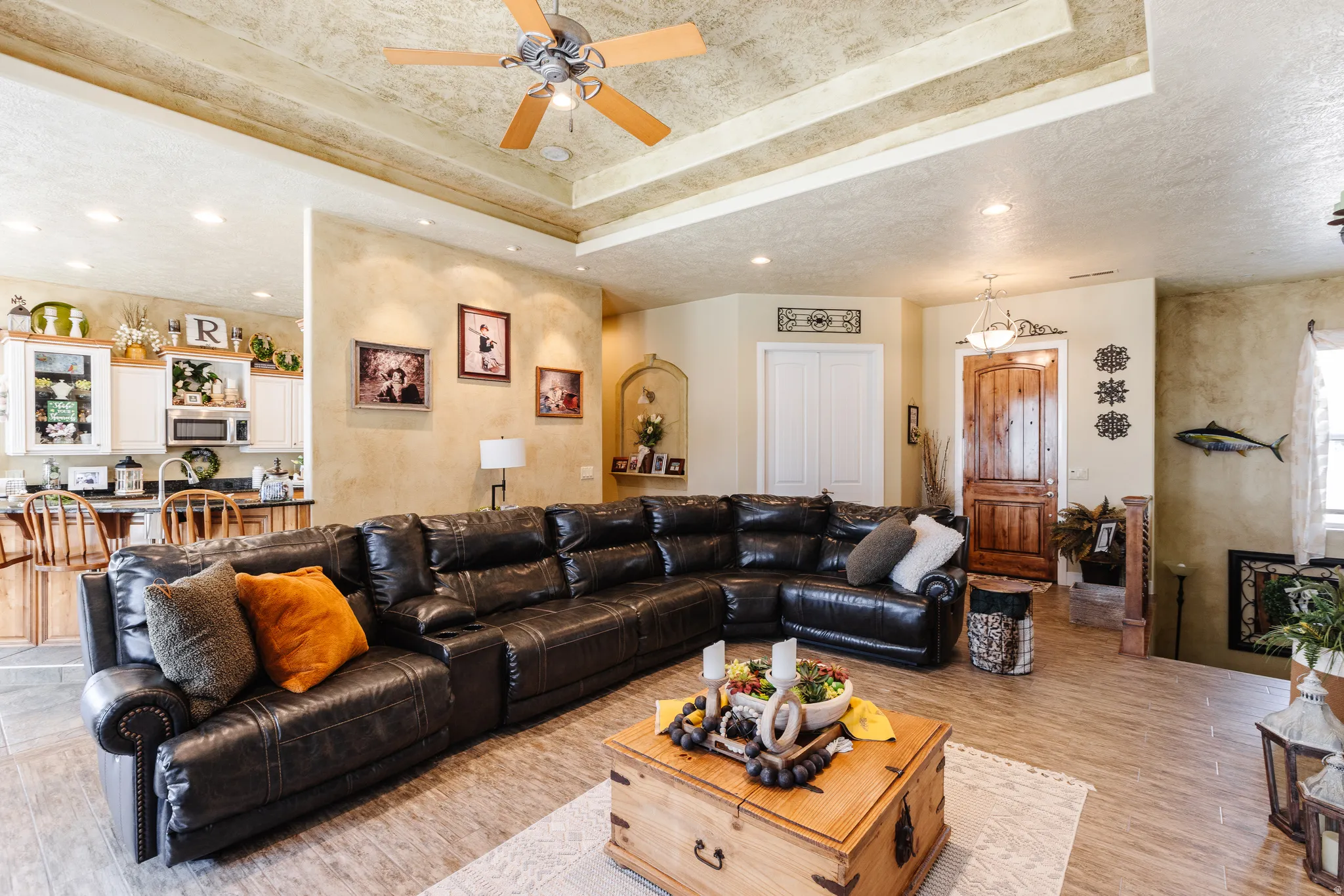 Living room featuring a ceiling fan, recessed lighting, a textured ceiling, and light wood-style floors