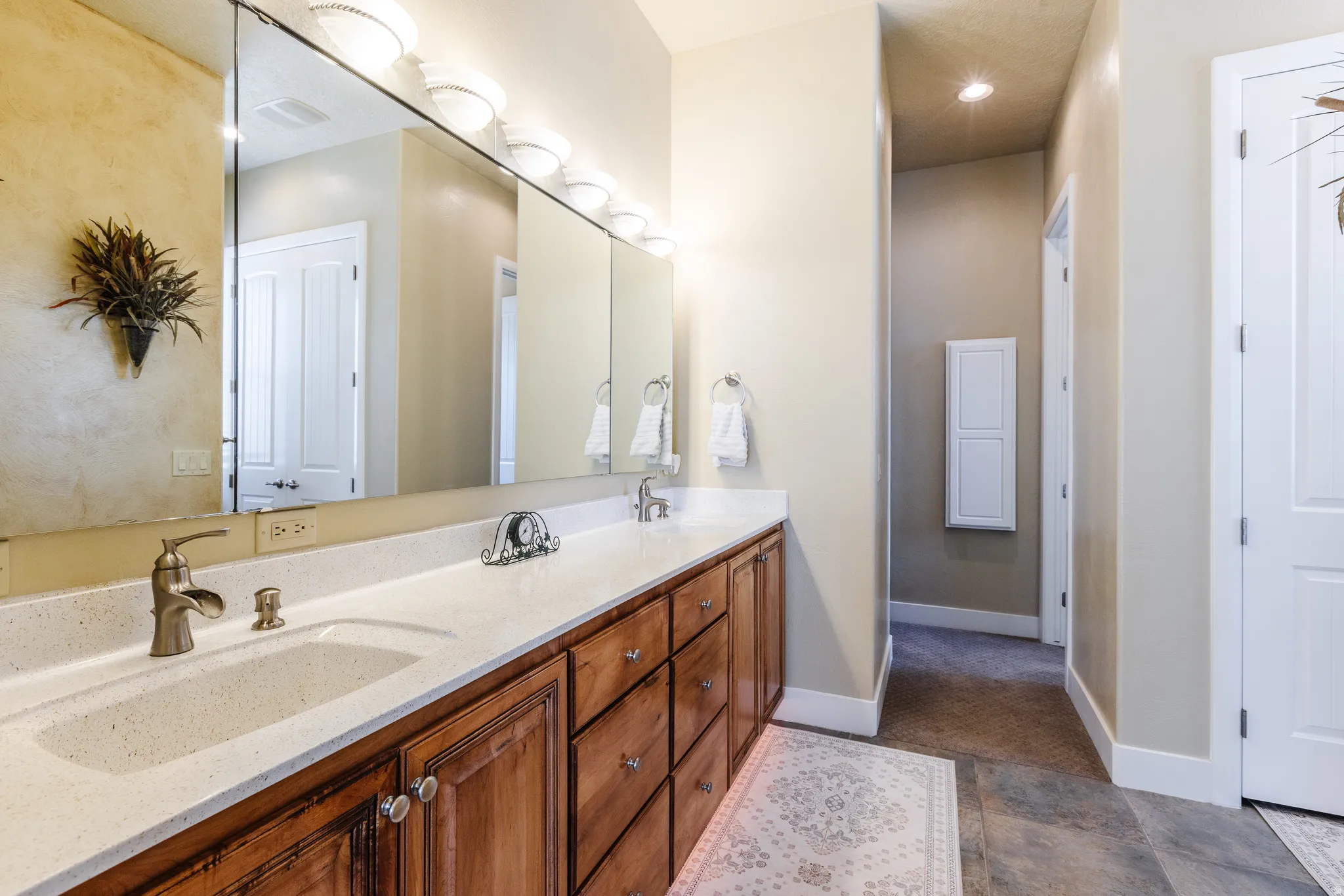 Full bath featuring double vanity and baseboards