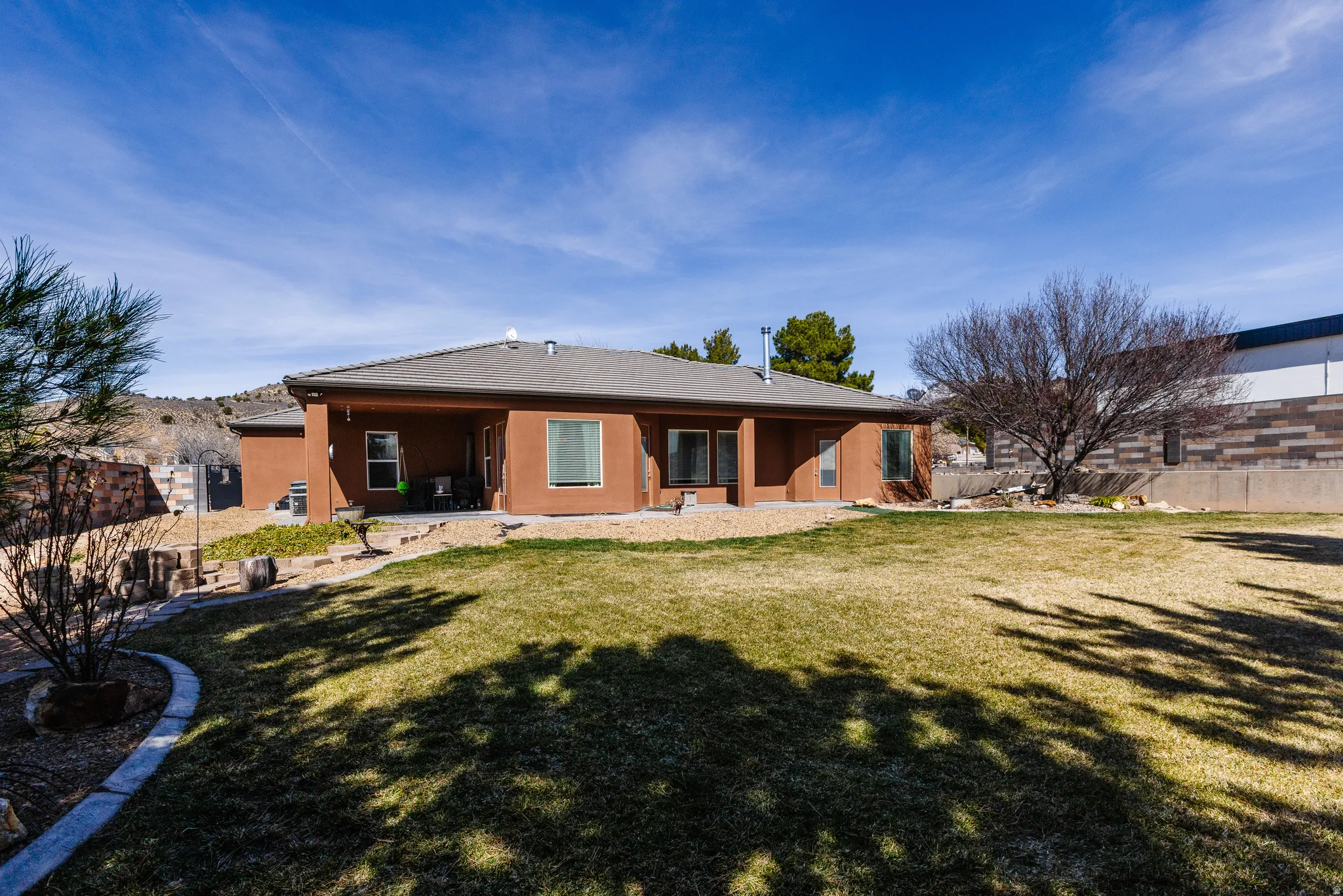 Back of house with a fenced backyard, a patio, and stucco siding