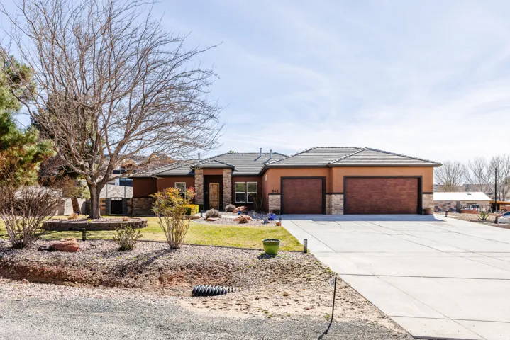 Prairie-style house with stone siding, an attached garage, concrete driveway, and stucco siding