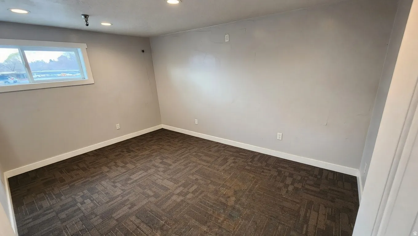 Empty room with baseboards and recessed lighting
