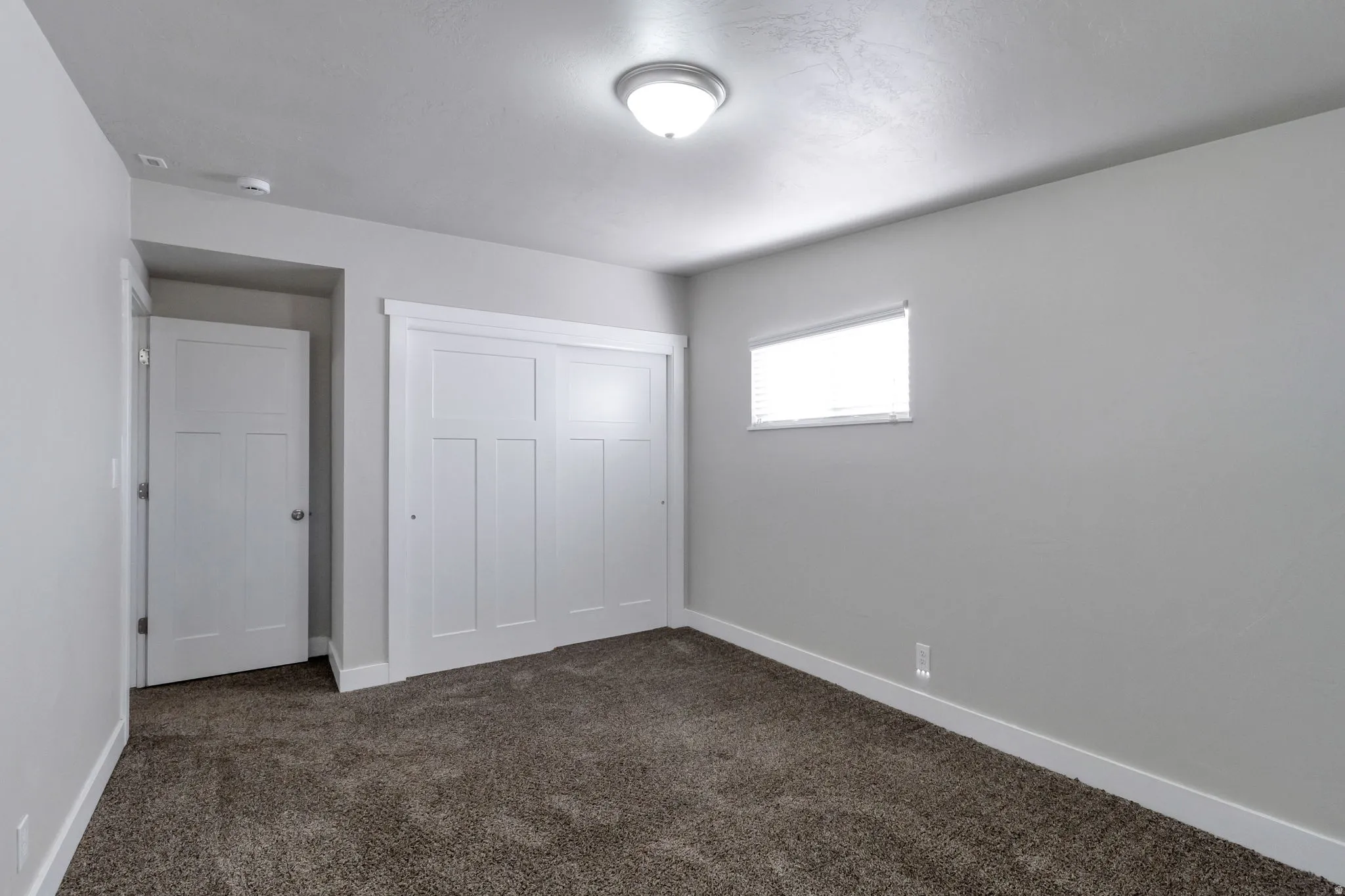 Unfurnished bedroom with dark colored carpet and a closet
