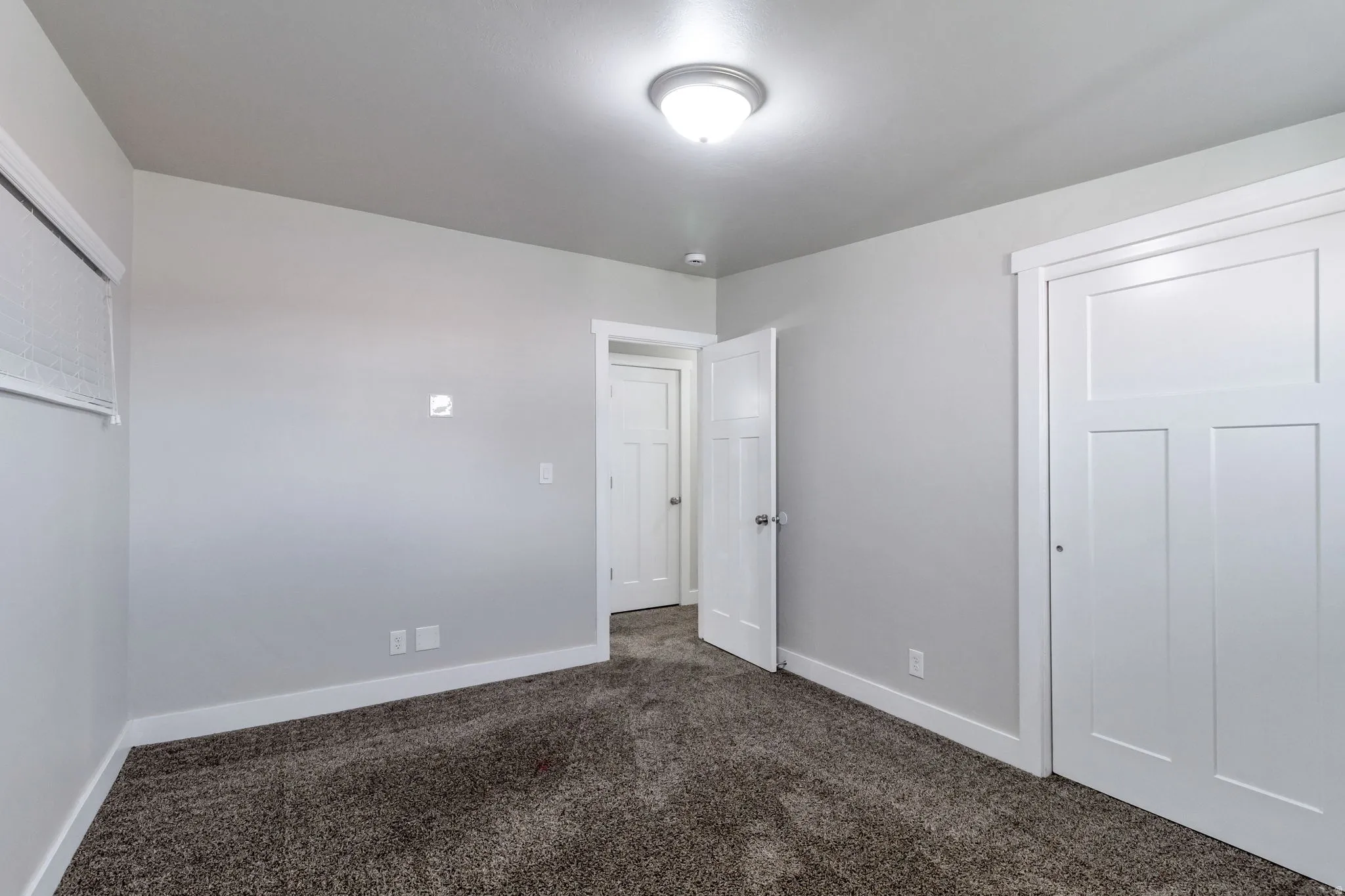 Unfurnished bedroom with dark colored carpet and a closet