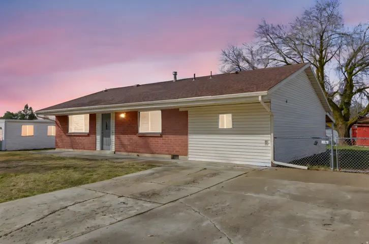 View of front facade with brick siding and a shingled roof