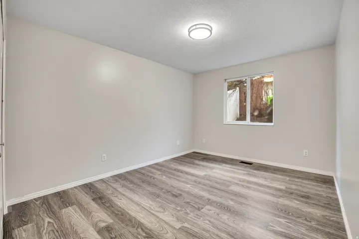 Empty room featuring light wood-style floors and a textured ceiling