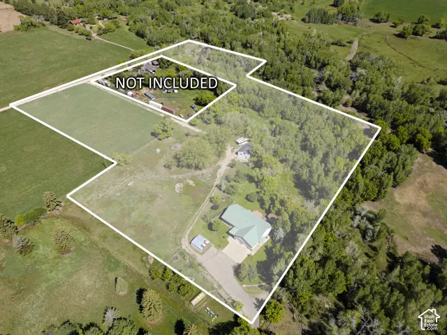 Aerial perspective showcasing a substantial land parcel with mature tree coverage and open fields