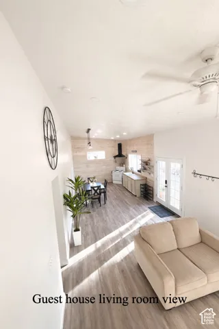 Living room with light wood-style flooring, french doors, and wooden walls