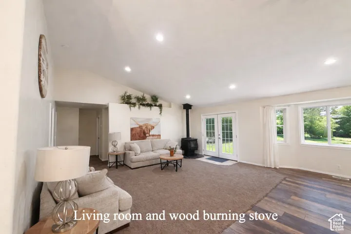 Living room with wood burning stove, french doors, bay windows.