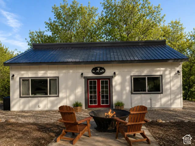 White vertical siding exterior with a dark metal roof