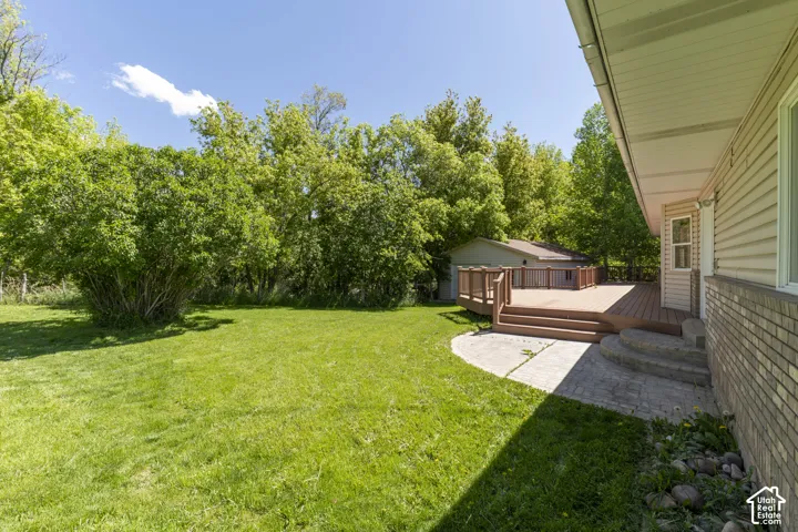 Back deck and backyard with view of detached garage/shop.