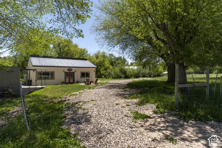 Gravel driveway leading to a single-story structure with a metal roof