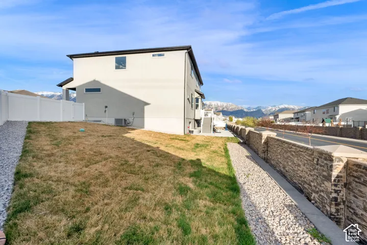 Rear view of property with a fenced backyard and a mountain view