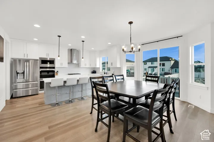 Dining space featuring light wood finished floors and a chandelier