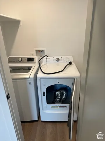 Laundry room featuring separate washer and dryer and dark wood finished floors