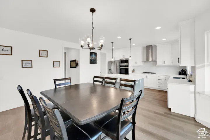Dining space with light wood-style floors and a chandelier