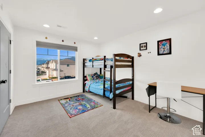 Bedroom with light carpet and recessed lighting